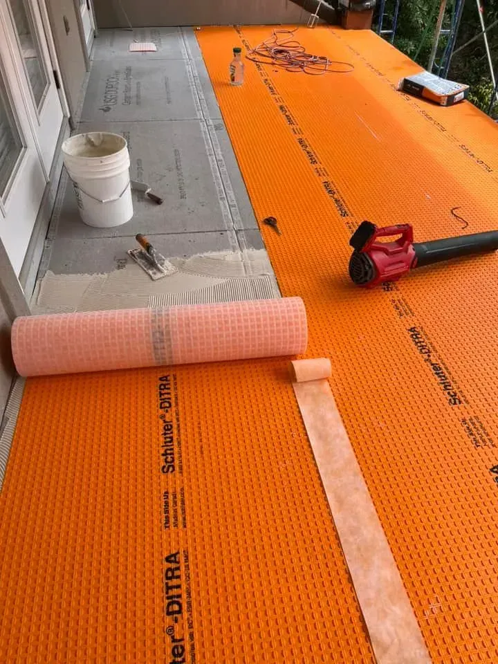 A blower is sitting on top of an orange mat on a balcony.