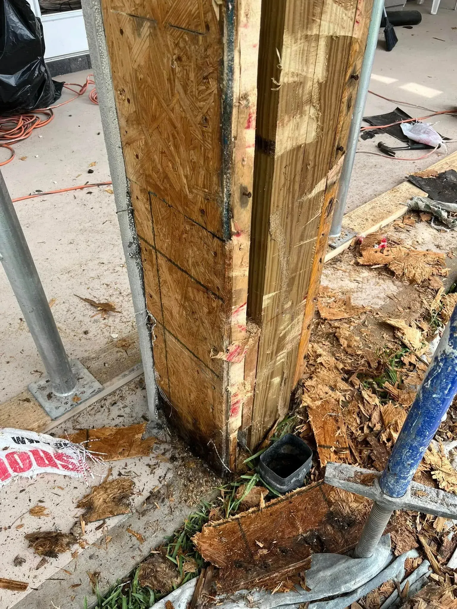 A wooden post is being removed from a building with a shovel.