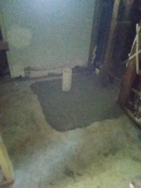 A dirty room with a bucket on the floor.