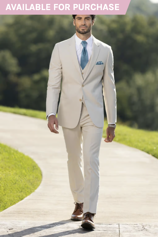 Man in a cream suit and tie walking on a curved outdoor path