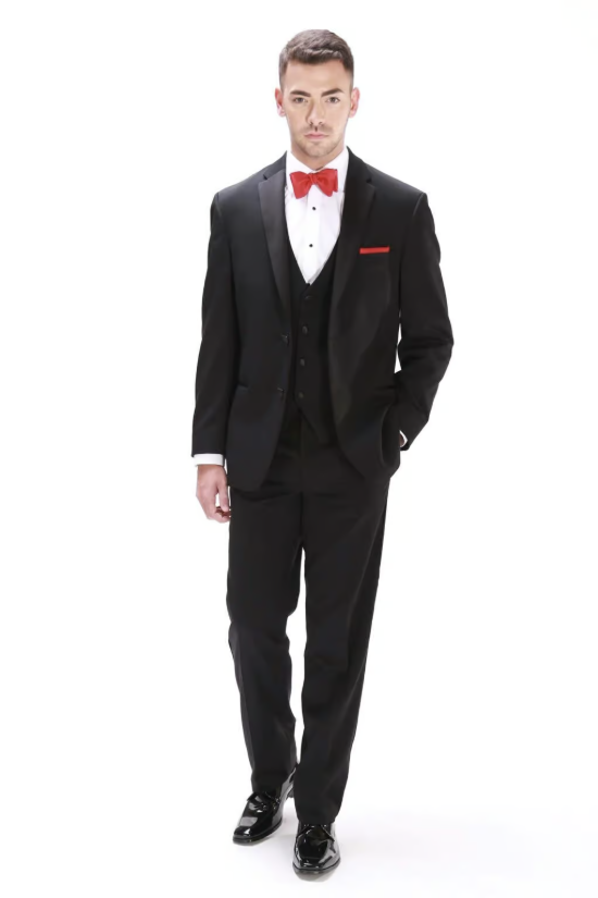 Man in a black tuxedo with a red bow tie and pocket square, standing against a white background.