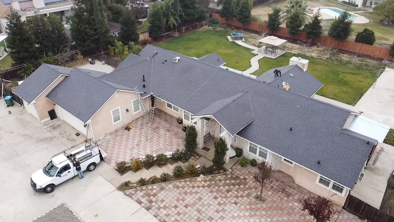 An aerial view of a large house with a truck parked in front of it.