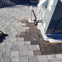 A roof with a broken shingle and a box on it.