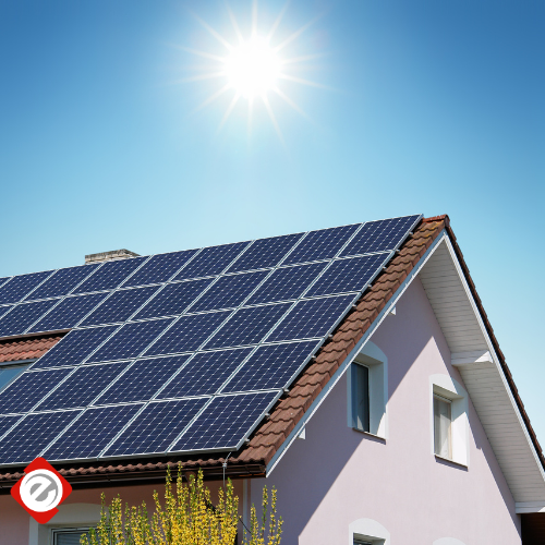 Solar panels on a house roof under a bright sun.