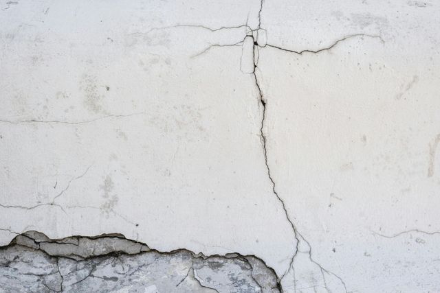 A close up of a cracked white wall.