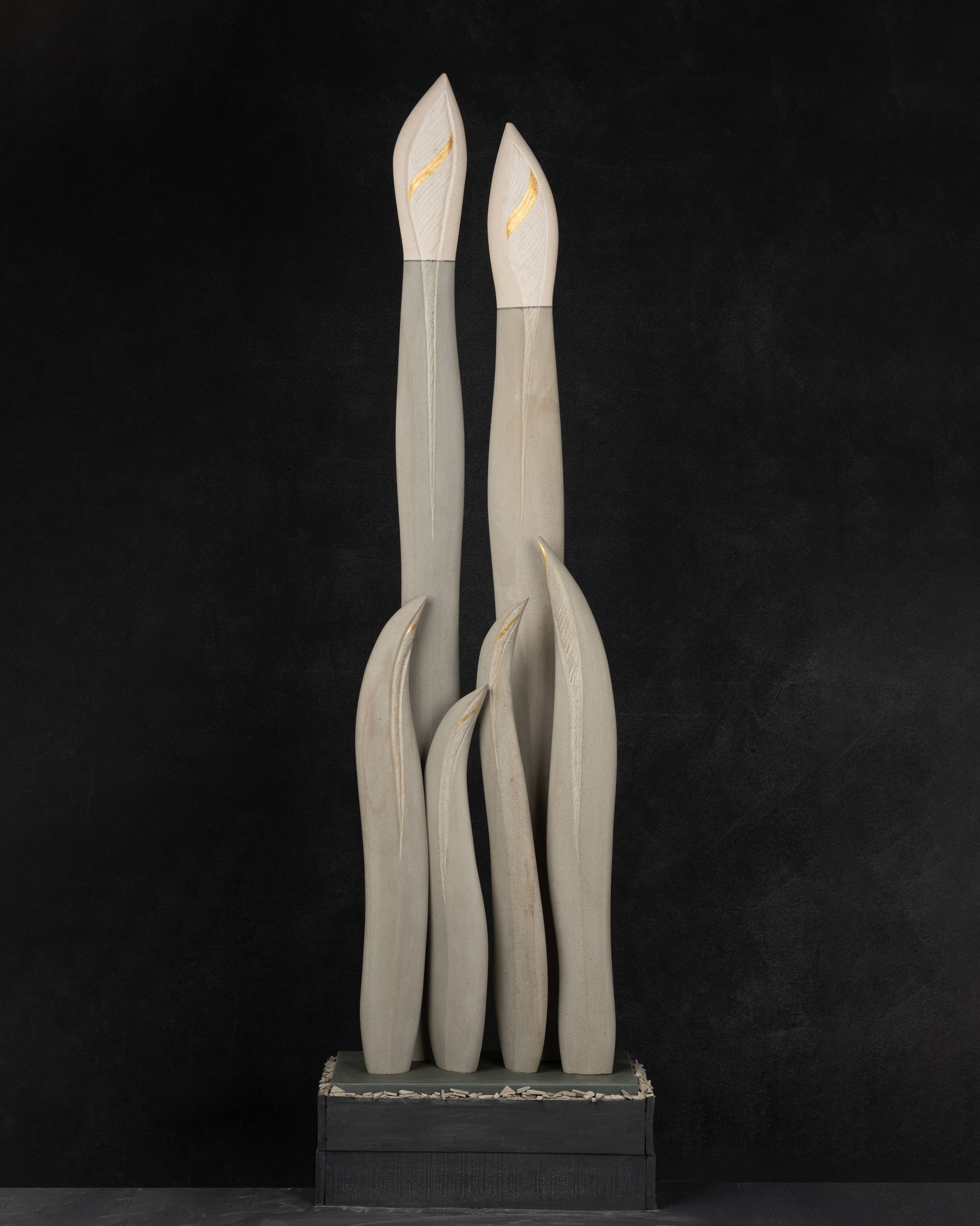 A statue of three candles on a black background