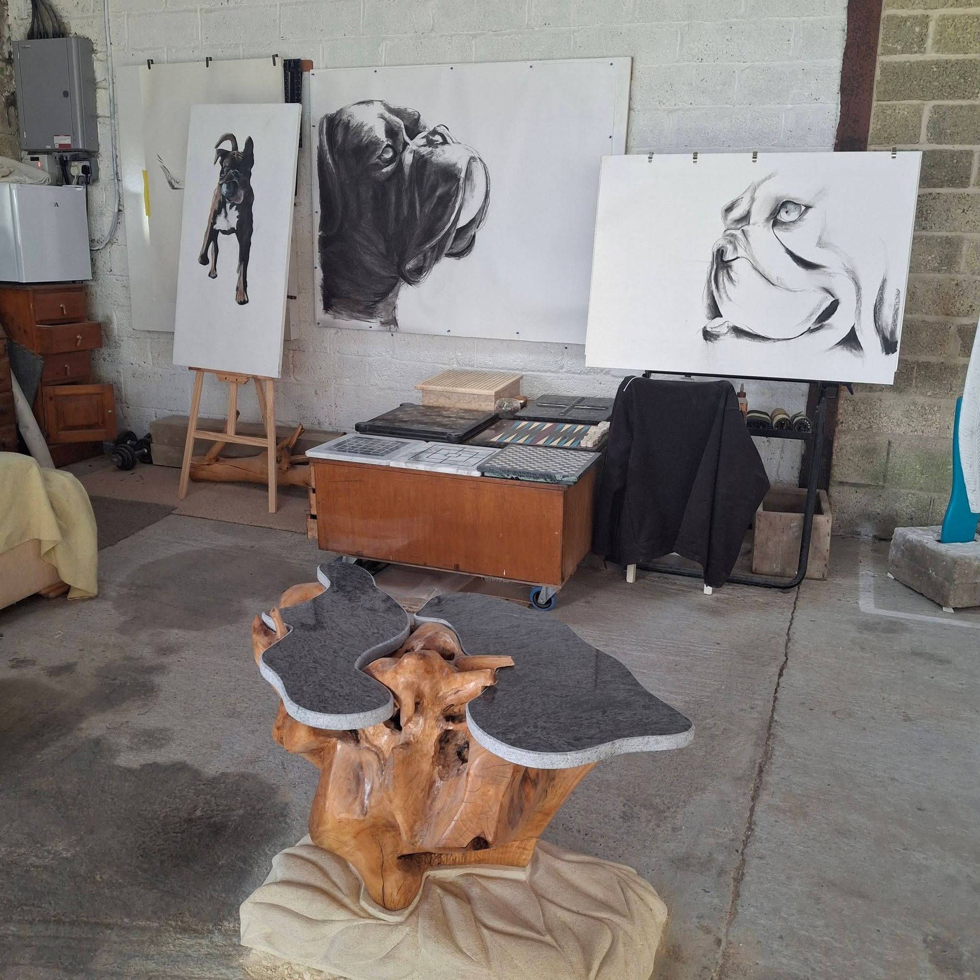 Art studio with charcoal animal sketches on easels and a carved wooden table centerpiece