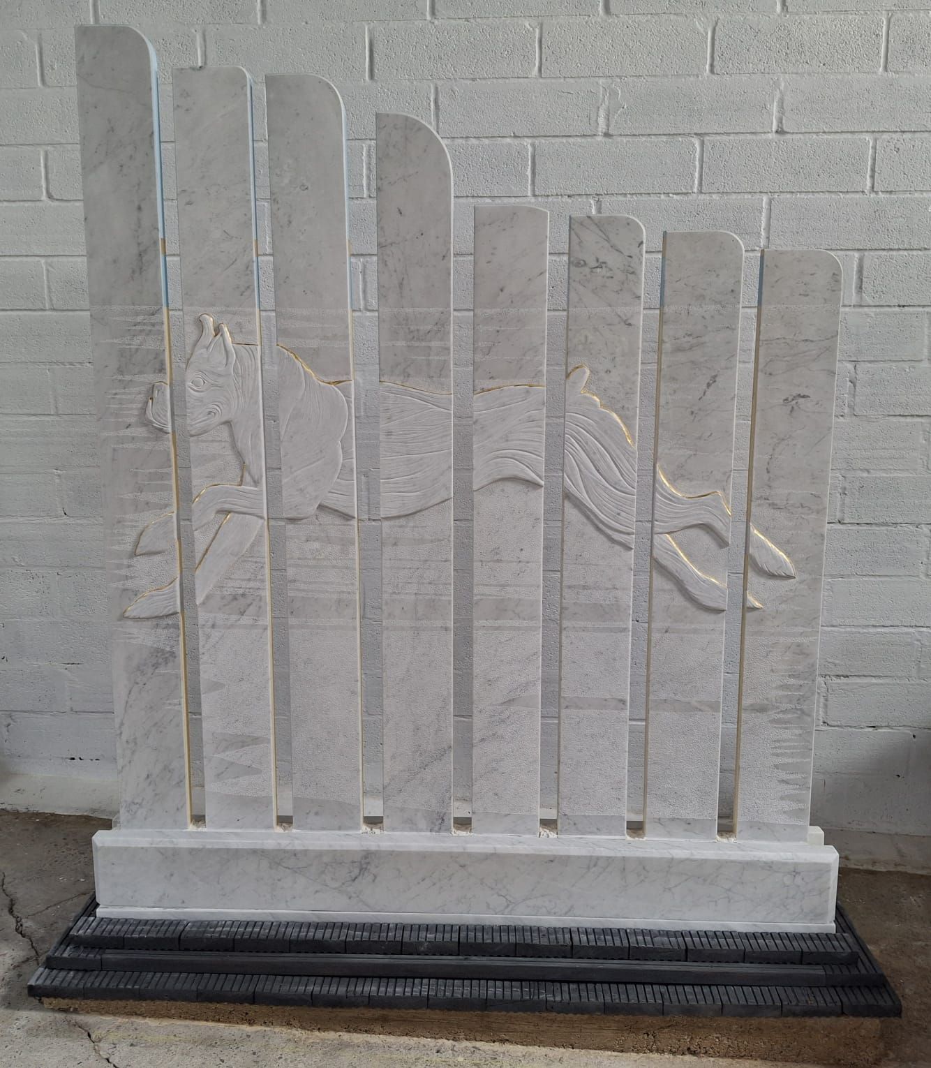 A white fence with a brick wall in the background