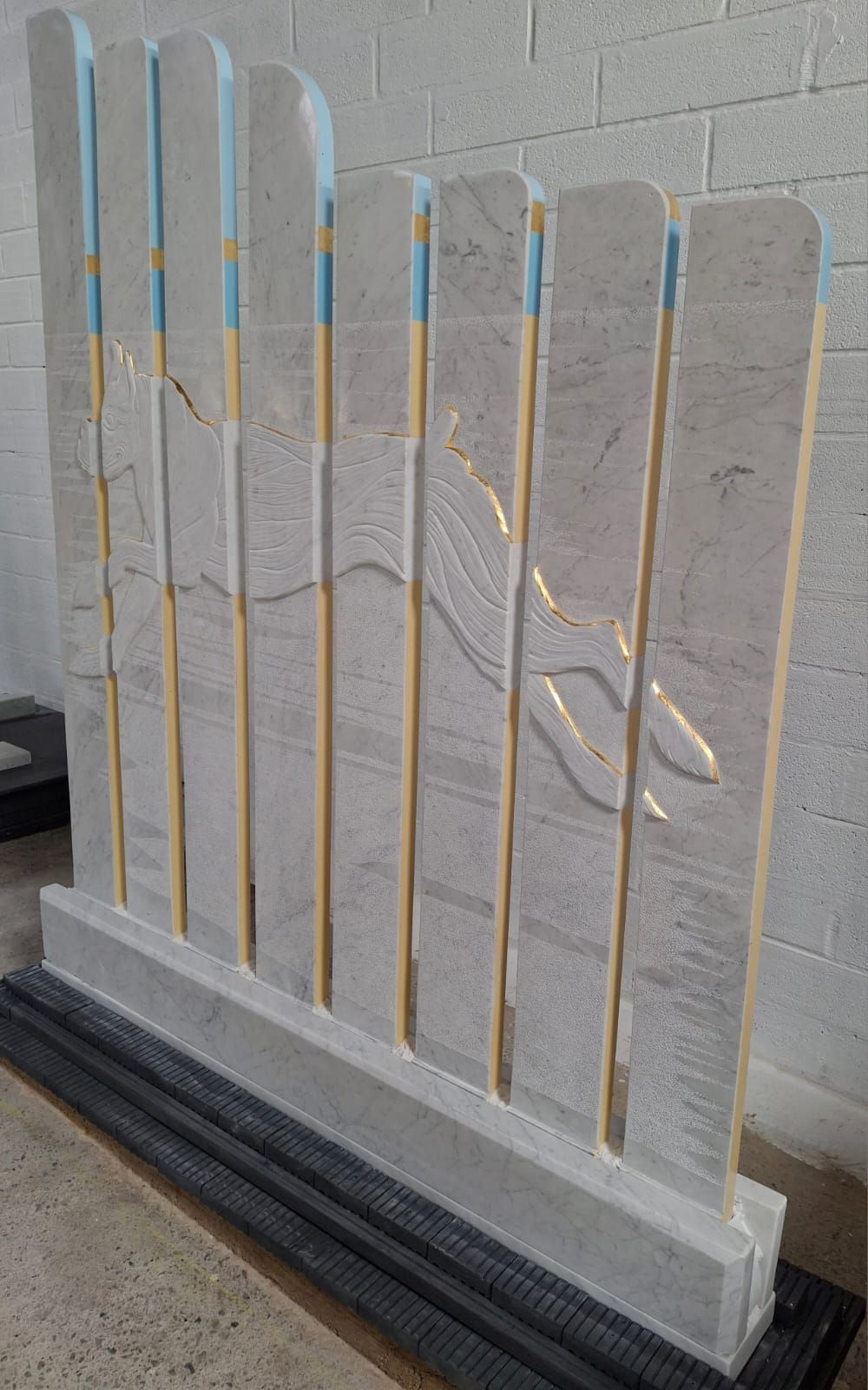 A white fence with a brick wall in the background