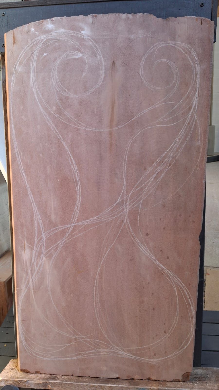 A piece of red stone with a drawing on it is sitting on a table.