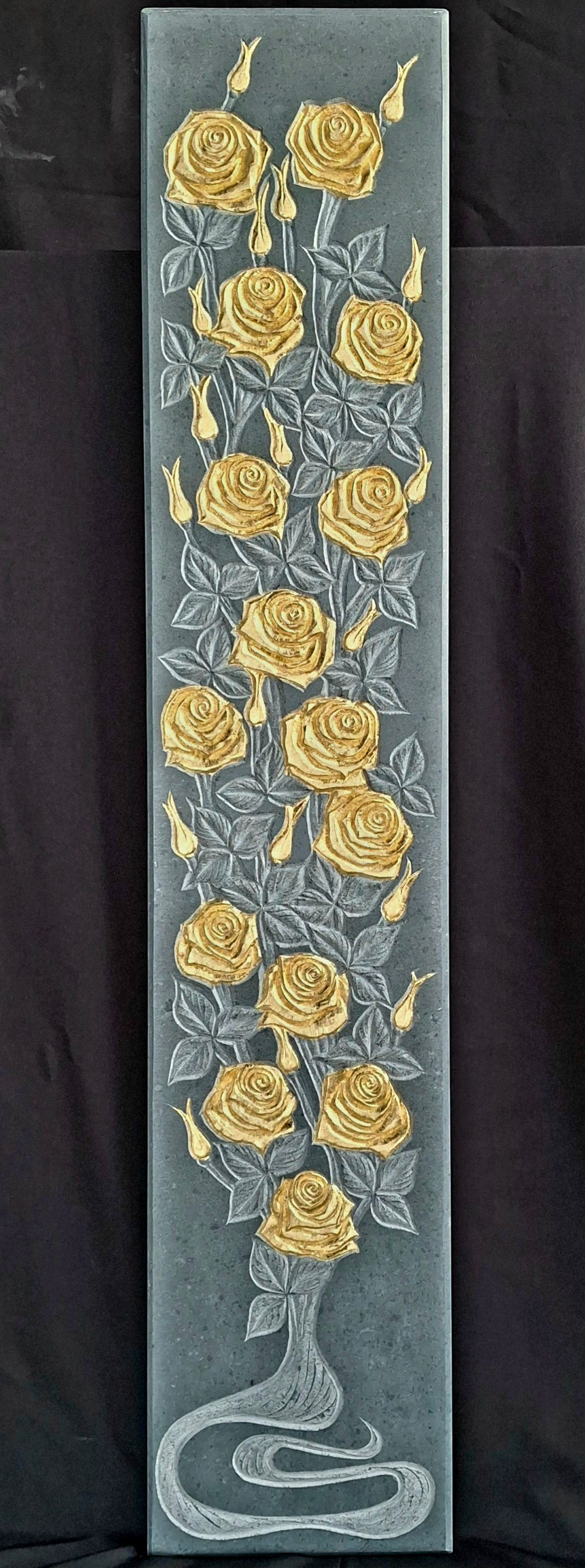 Vertical strip of blue fabric embroidered with gold flowers and a white vase at the bottom