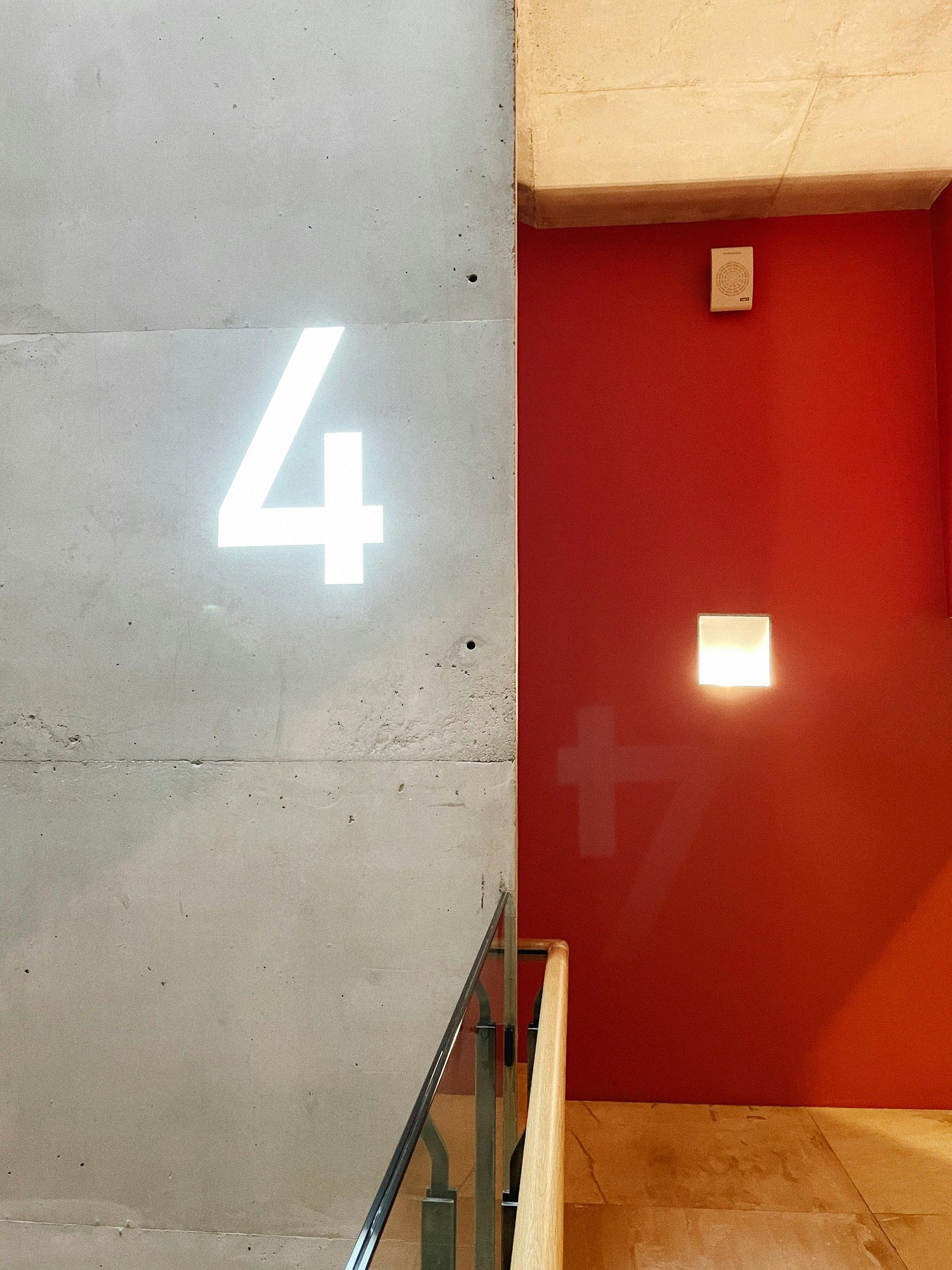 Glowing number 4 hanging on a grey wall