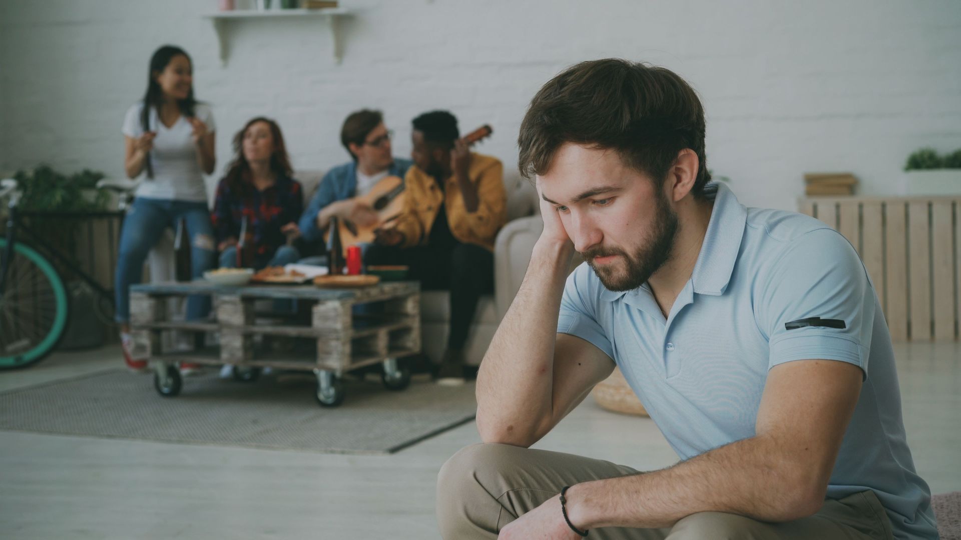 Man sitting alone with group in the background