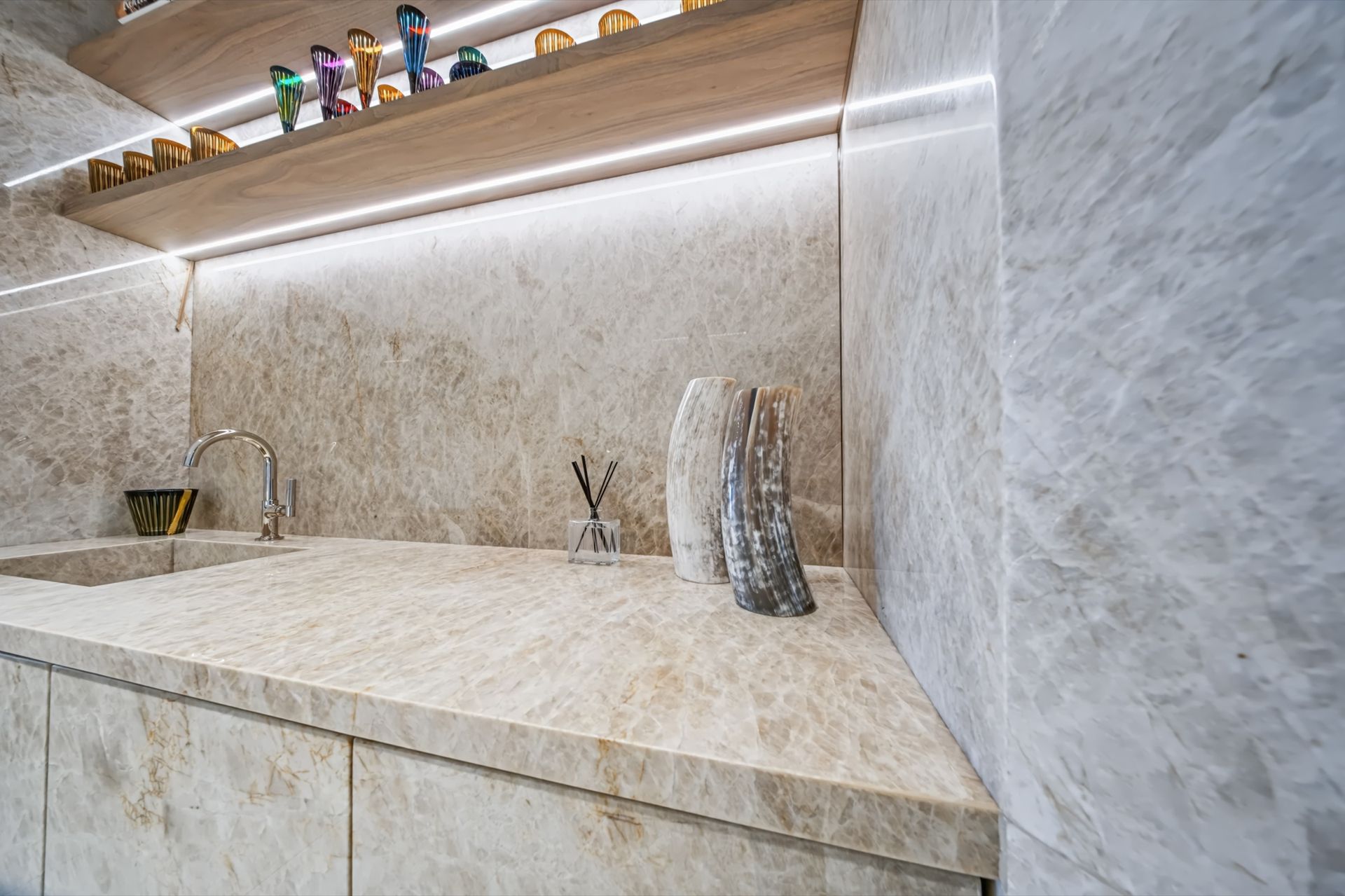 Lounge and bar with Taj Mahal stone and illuminated cabinetry, Finn Residence at Alina Residences, Boca Raton