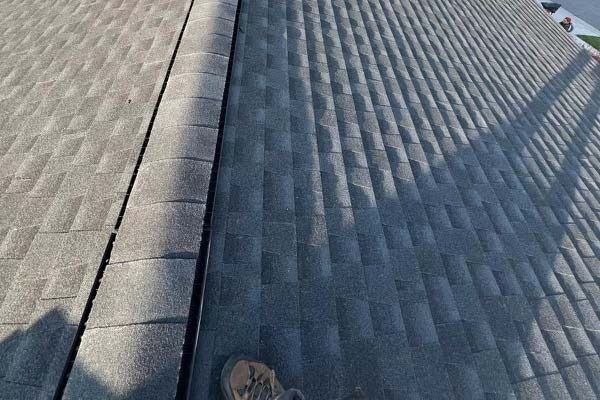 Roof shingles and ridge cap seen from above, with a small boot visible at the bottom