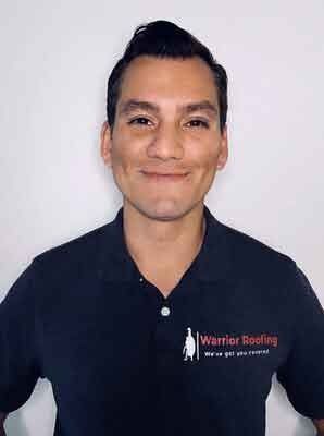 Smiling person in a black Warner Roofing polo shirt against a light background