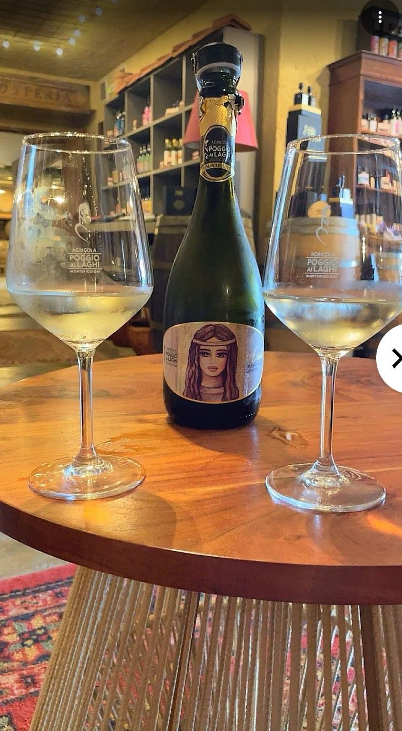 Champagne bottle between two empty flutes on a wooden table in a warmly lit bar