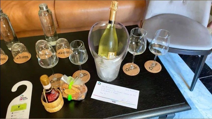 Wine tasting display with bottles, stemmed glasses, and numbered tags on a black tablecloth, one bottle in an ice bucket