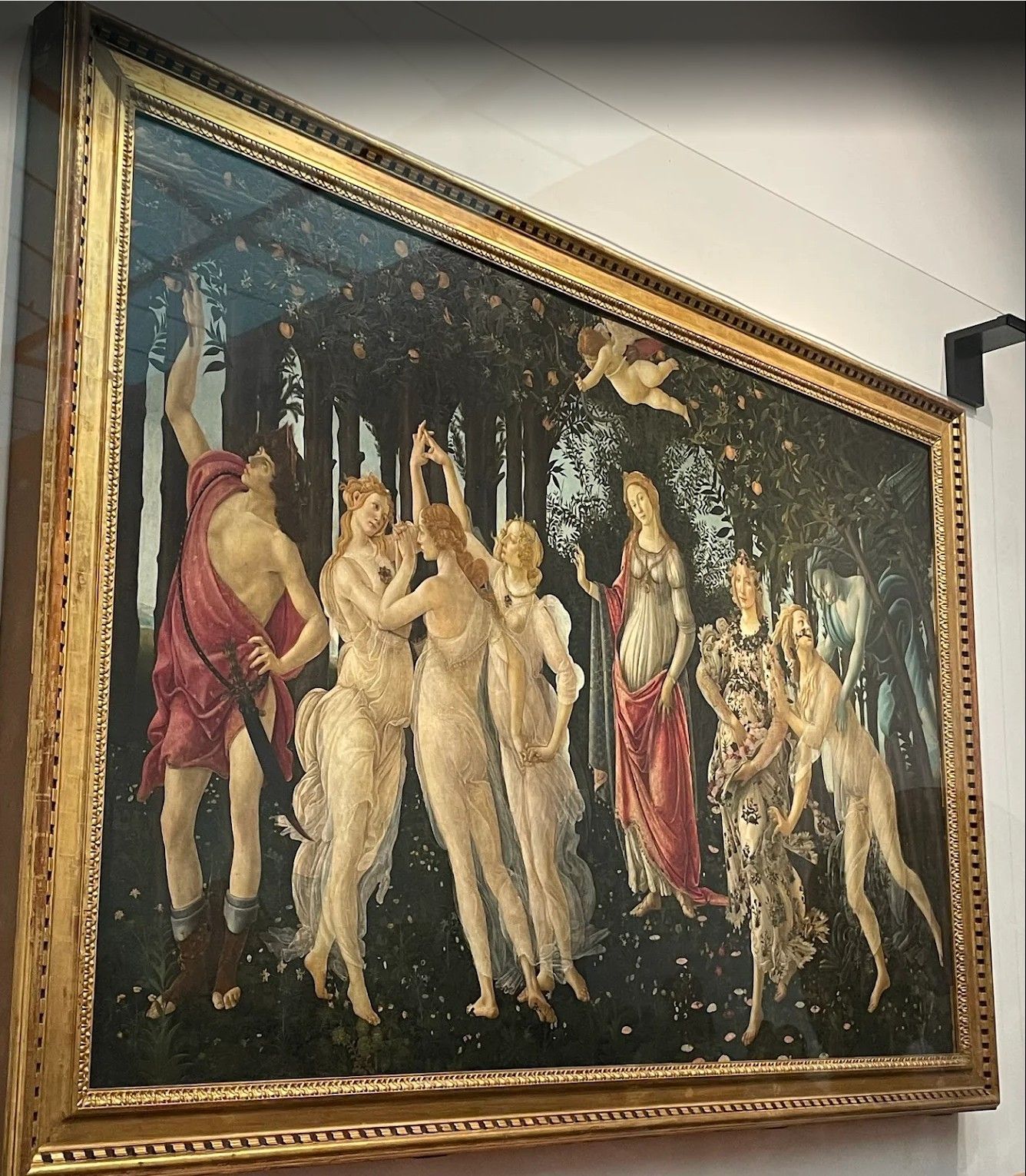 Framed classical painting of several nude figures dancing in a forest under a moonlit sky