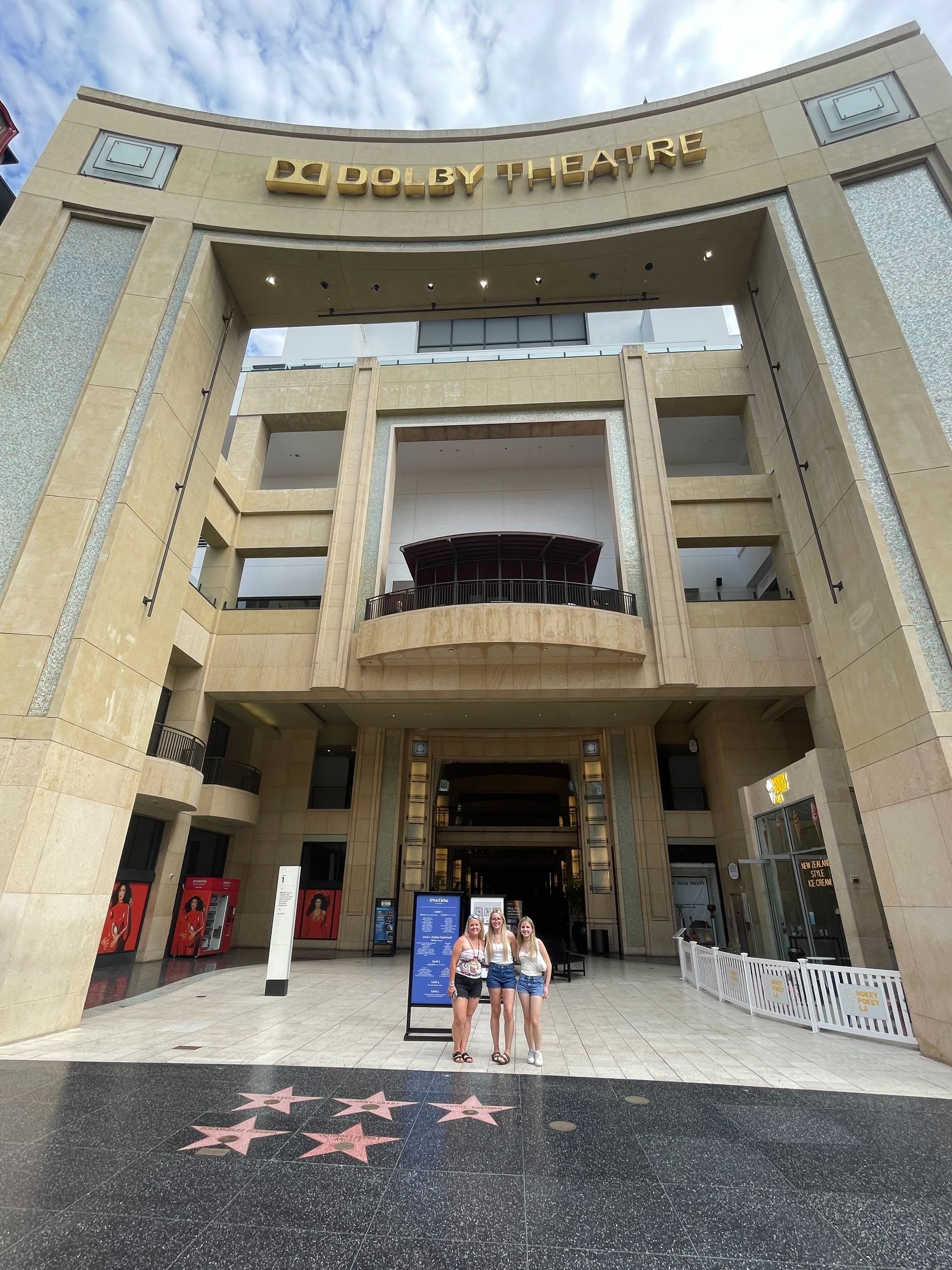 Hollywood Walk of Fame entrance with two people standing under a large archway