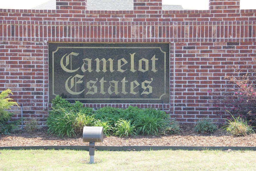 A brick neighborhood entrance sign reads