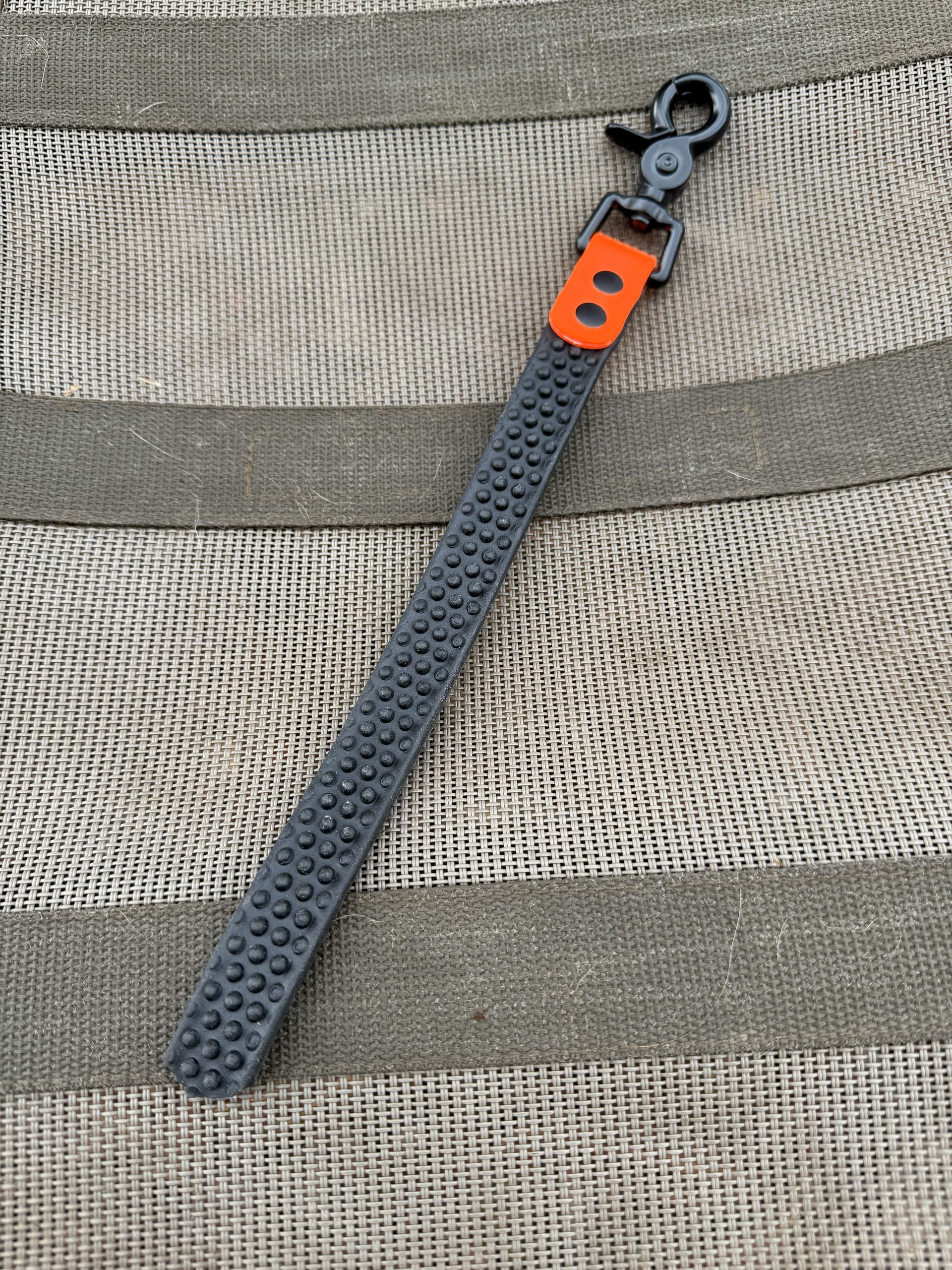 A textured grey strap attached to a black swivel clasp, accented with a bright orange rectangular detail.