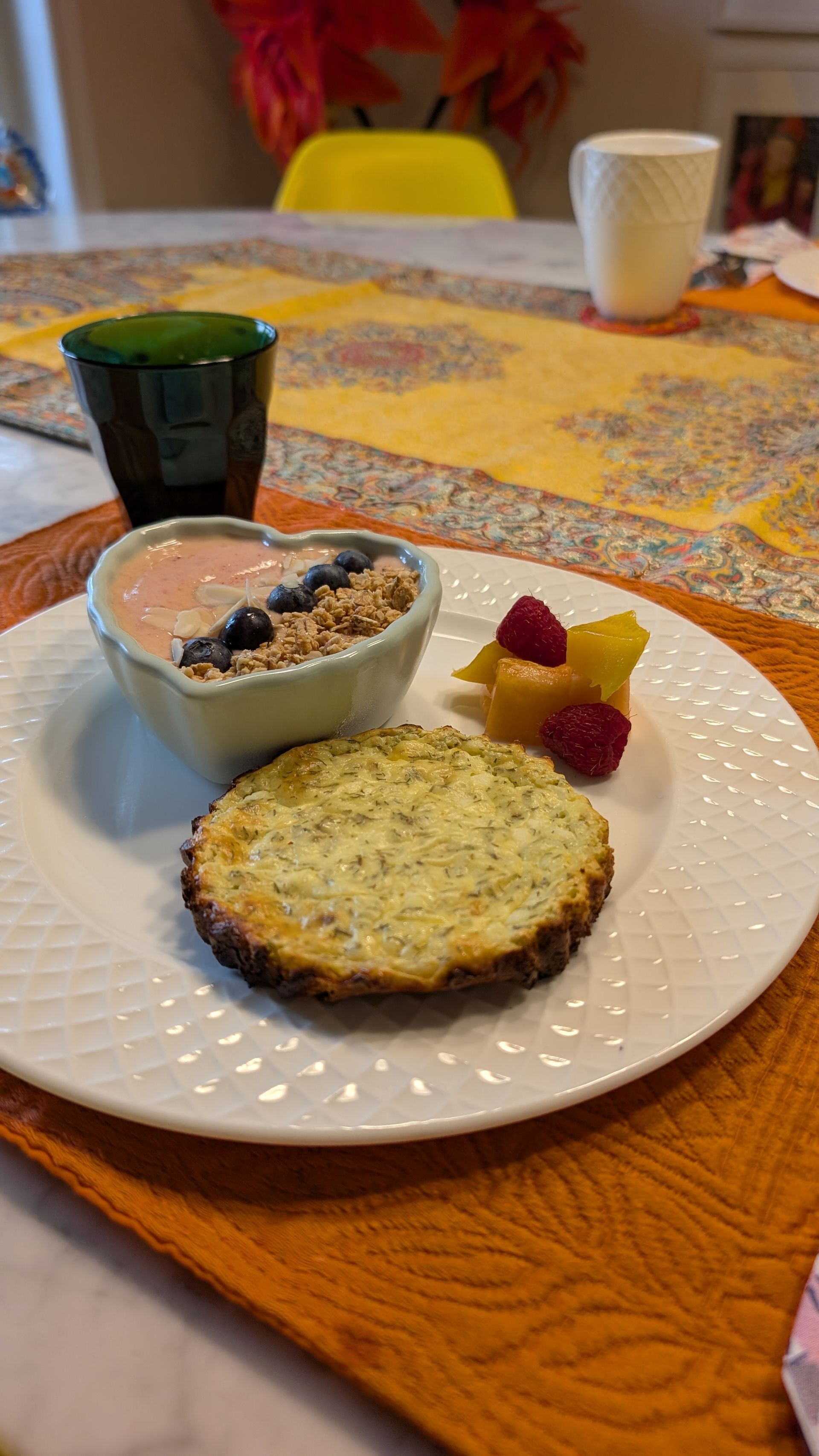 Breakfast plate with yogurt, berry muffin, fruit, and coffee on a table