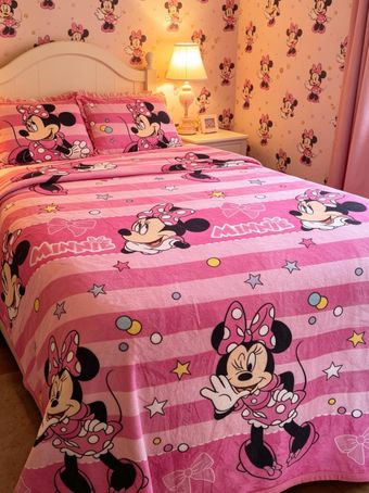 Colcha rosa con motivos de Minnie Mouse en un acogedor dormitorio con papel pintado floral y lámpara de noche encendida.