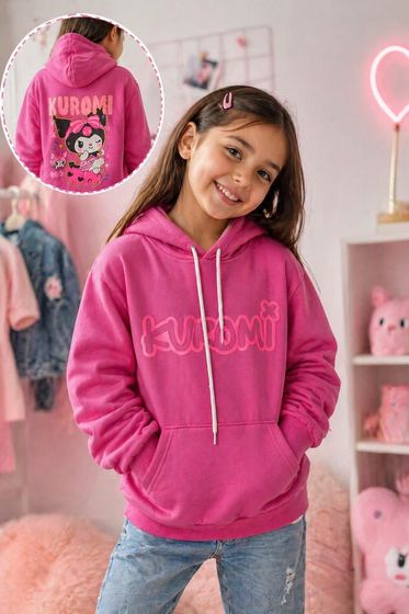 Sudadera rosa con estampado a juego en la espalda, usada por una persona sonriente en un ambiente acogedor de dormitorio.