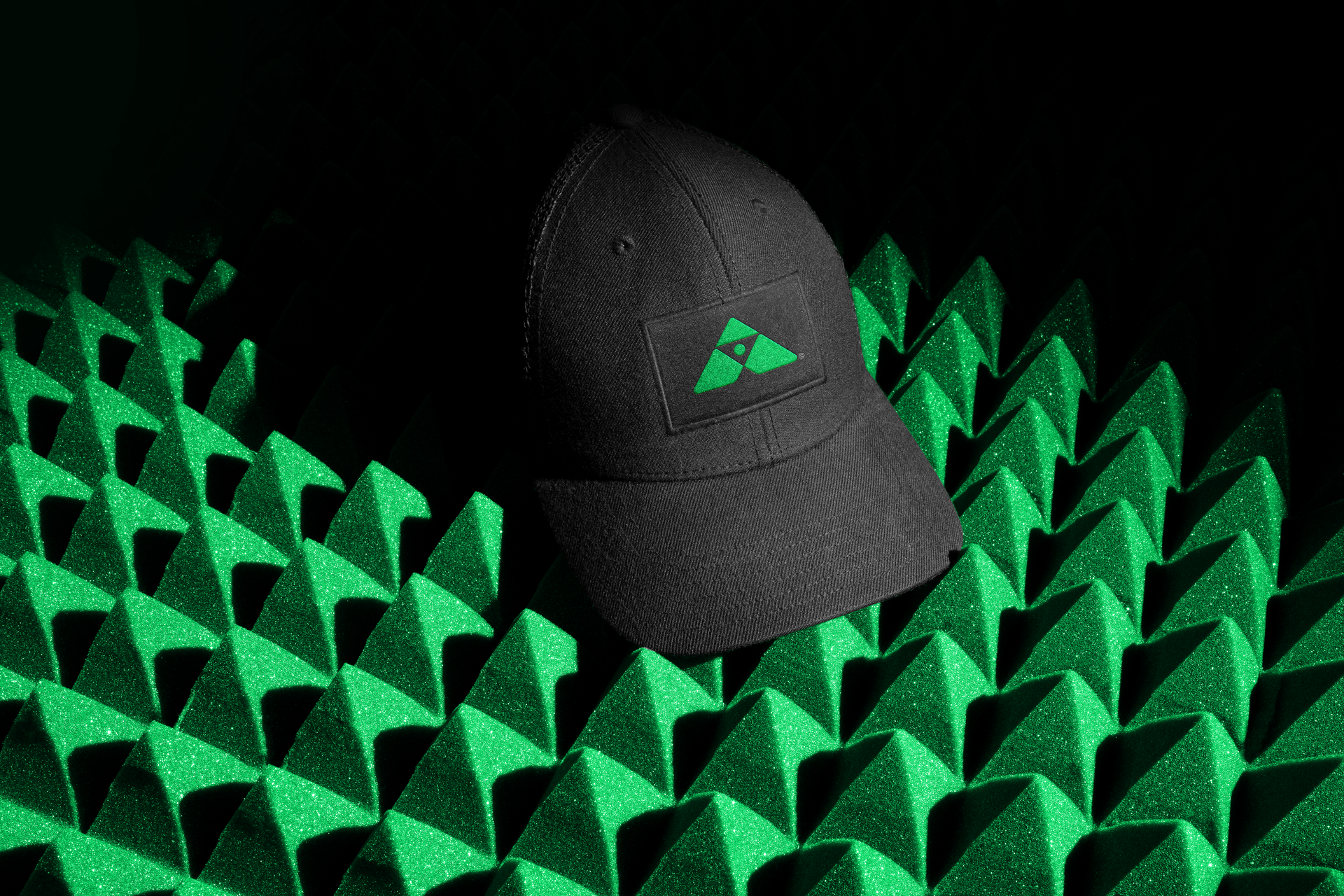 Um chapéu preto está sentado no topo de uma pirâmide verde
