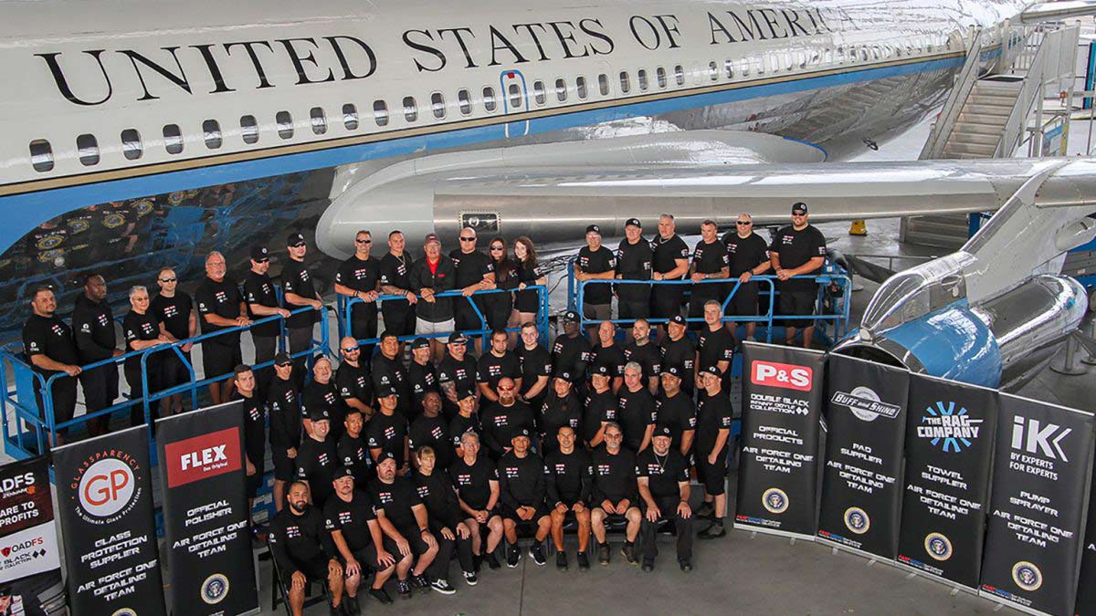 A group of people standing in front of a united states of america airplane