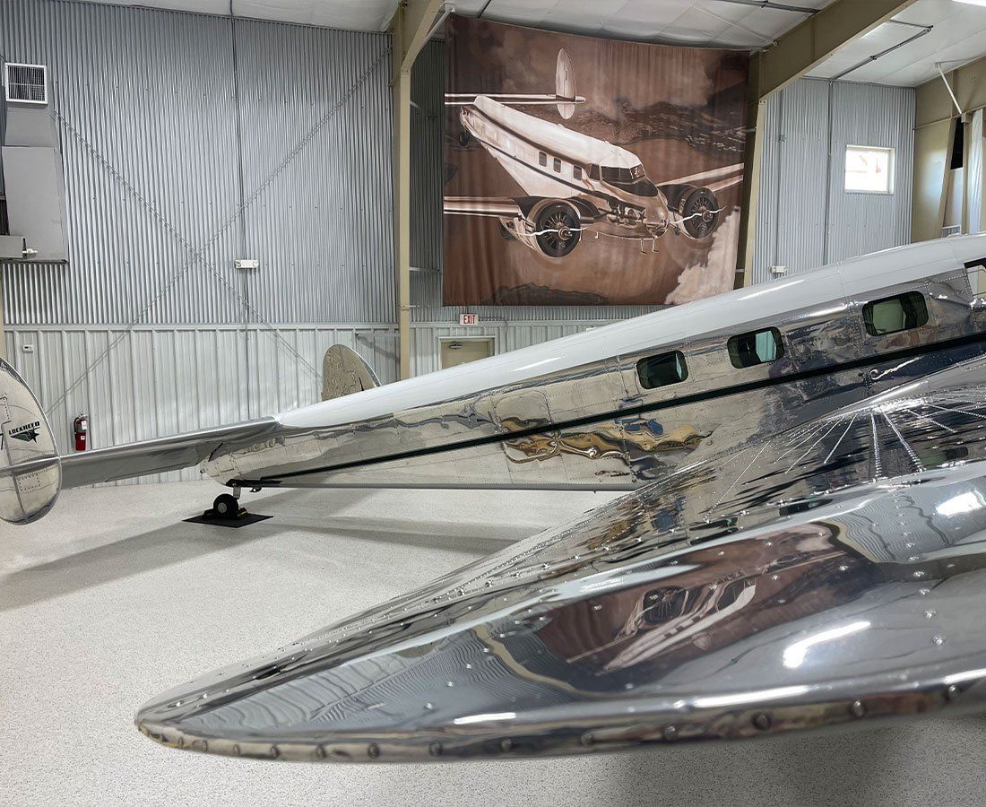 A silver airplane with a picture of an airplane on the wall behind it