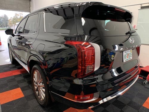 Black Hyundai Palisade SUV with tinted windows, parked indoors.