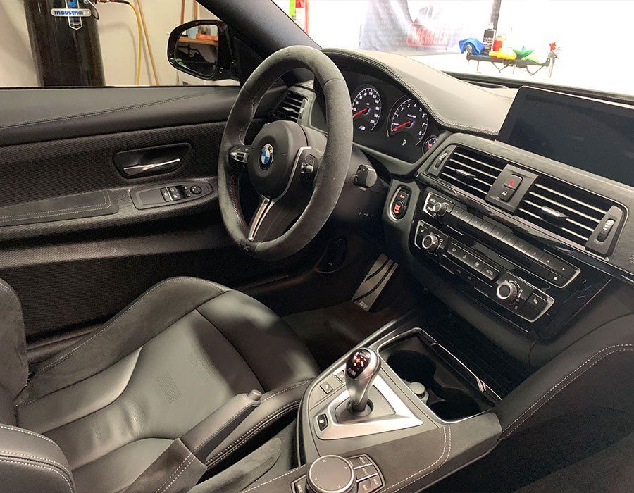 The interior of a bmw m4 is shown in a garage.