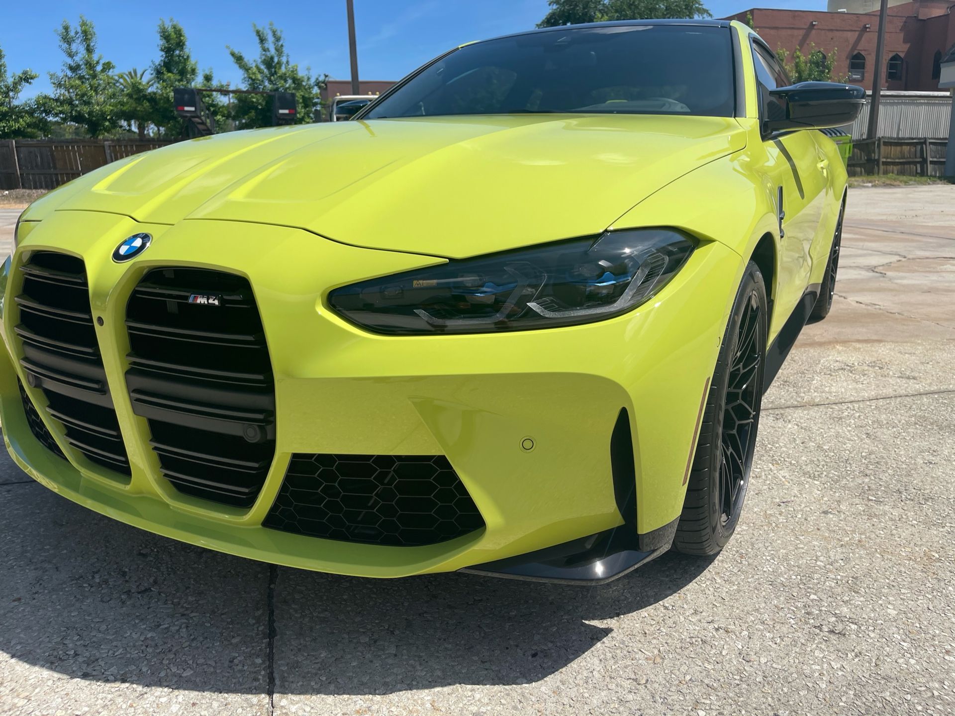 Luxury car receiving professional PPF maintenance with soft microfiber tools and low-pressure washing, extending paint protection film’s lifespan in Florida’s climate.