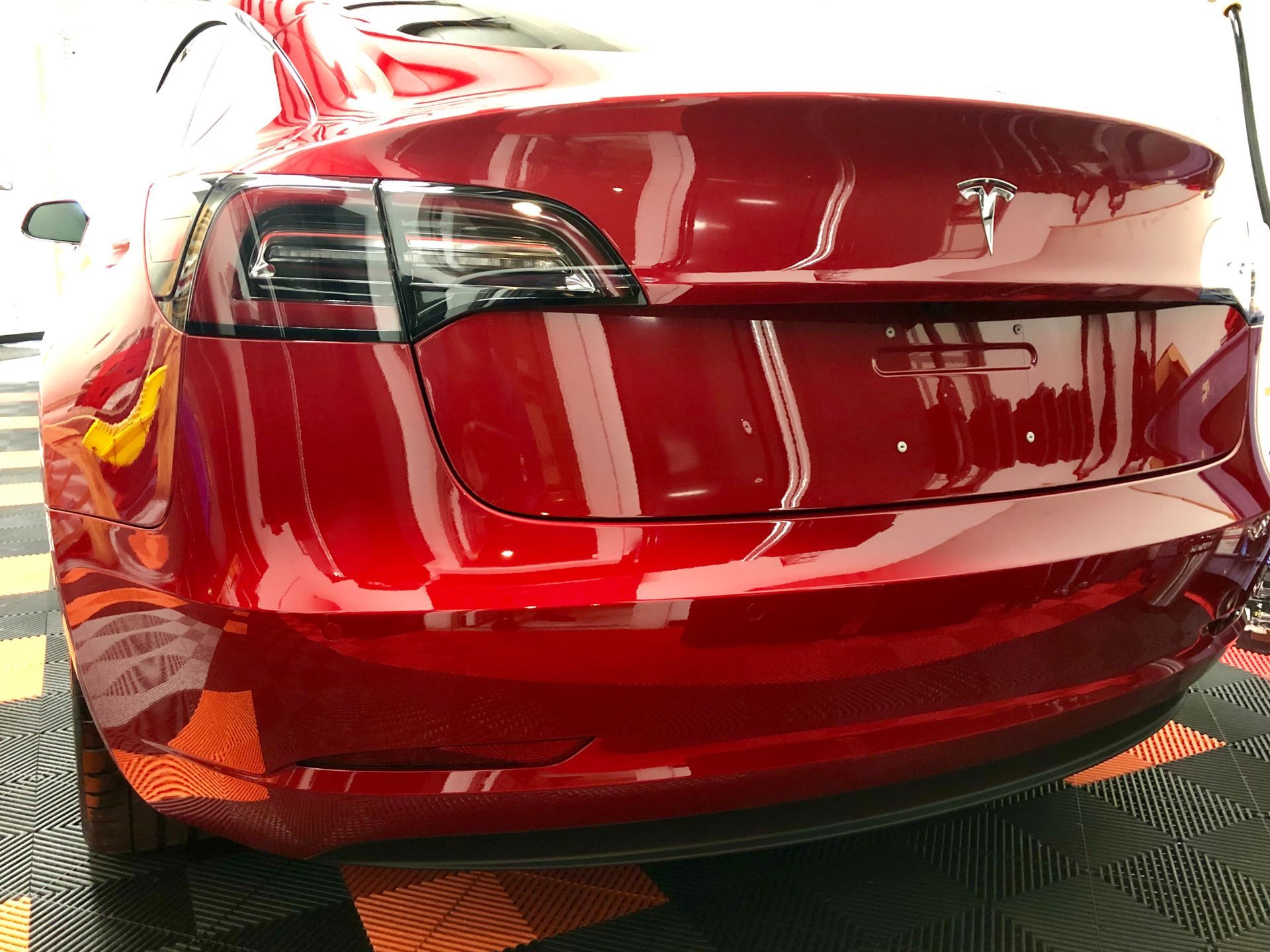 A luxury car reflecting a mirror-like gloss finish after ceramic coating application, showcasing long-term paint protection benefits.