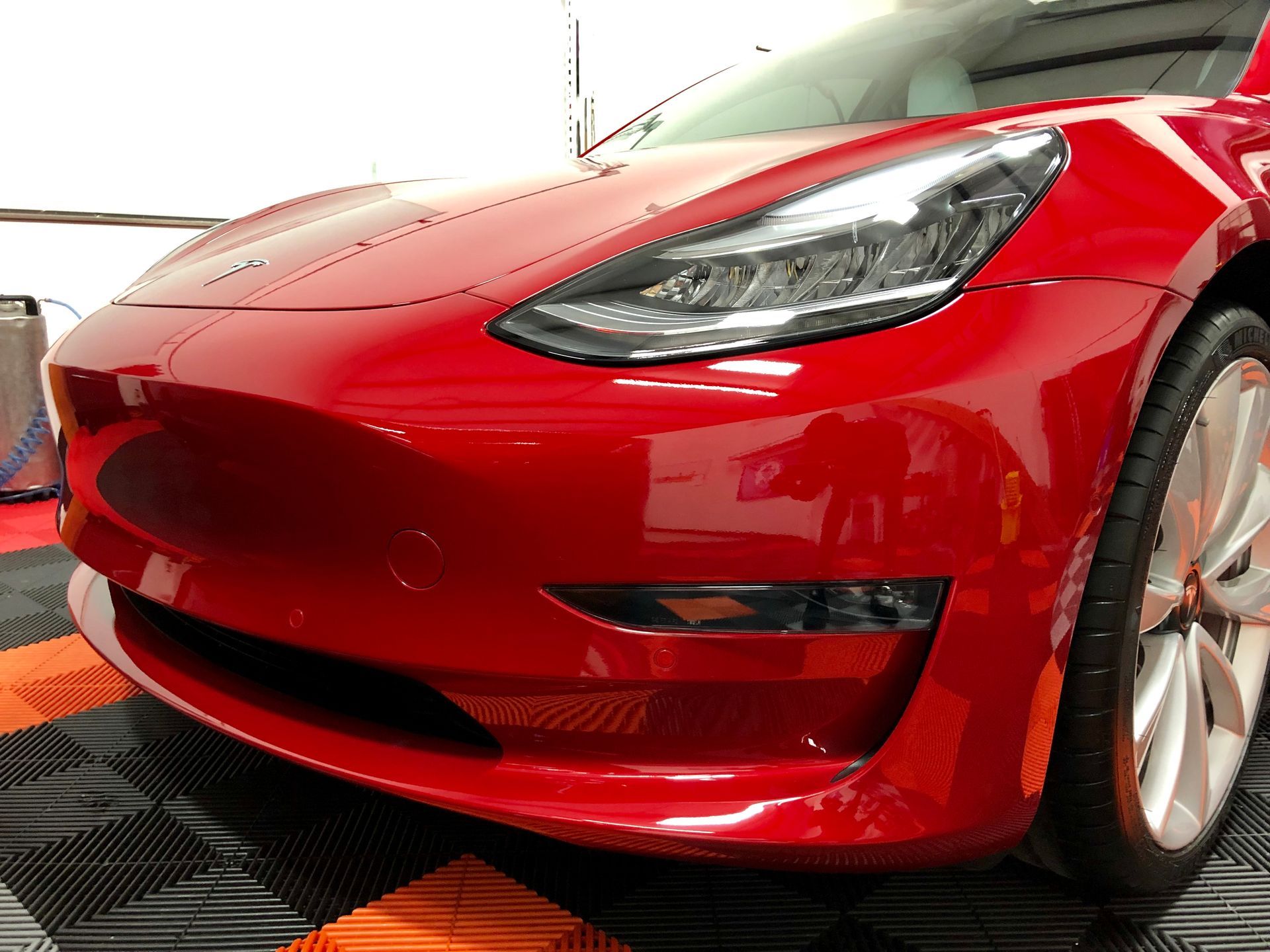 A luxury car reflecting a mirror-like gloss finish after ceramic coating application, showcasing long-term paint protection benefits.