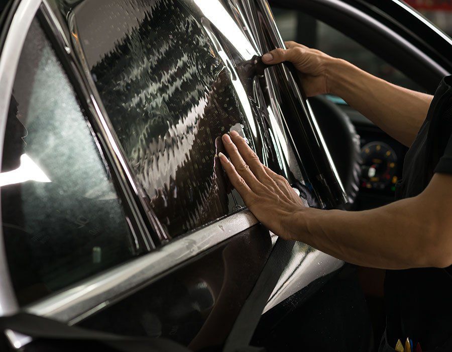 Close-up of tinted car windows in bright Florida sunlight showing protection against UV rays and interior fading.