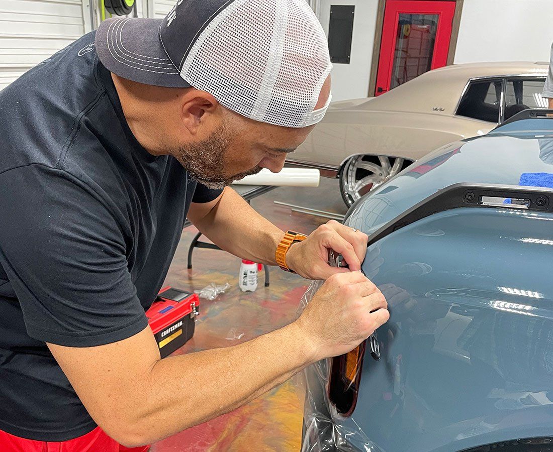 Person applying PPF on car