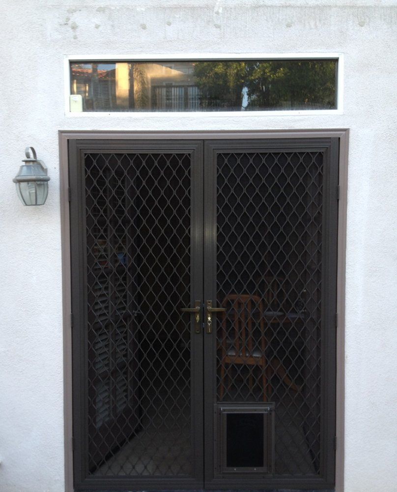 A door with a dog door in it is on a white wall.