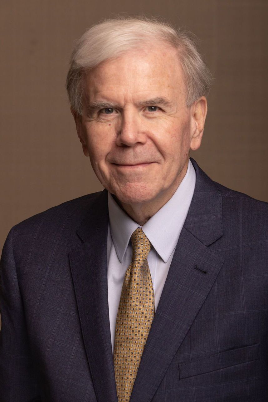 A man in a suit and tie is smiling for the camera.