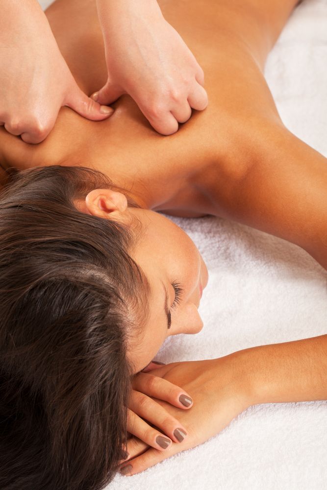 Person Receiving a Shoulder Massage, Face Down on a White Towel — Leela Thai Massage & Spa in Newtown, QLD