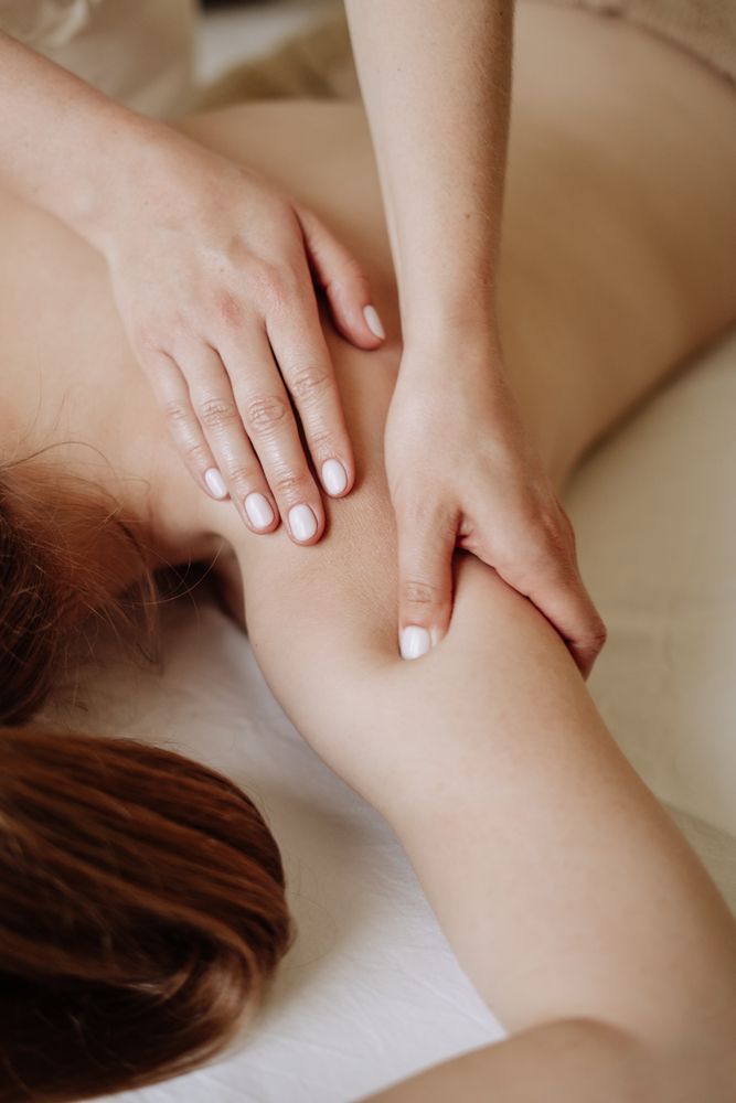 Hands Giving a Shoulder and Arm Massage on a Person Lying Face Down — Leela Thai Massage & Spa in Newtown, QLD