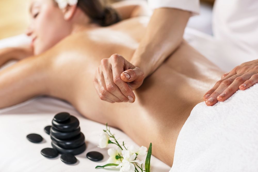 Woman Receiving a Back Massage With Hot Stones in a Spa — Leela Thai Massage & Spa in Newtown, QLD