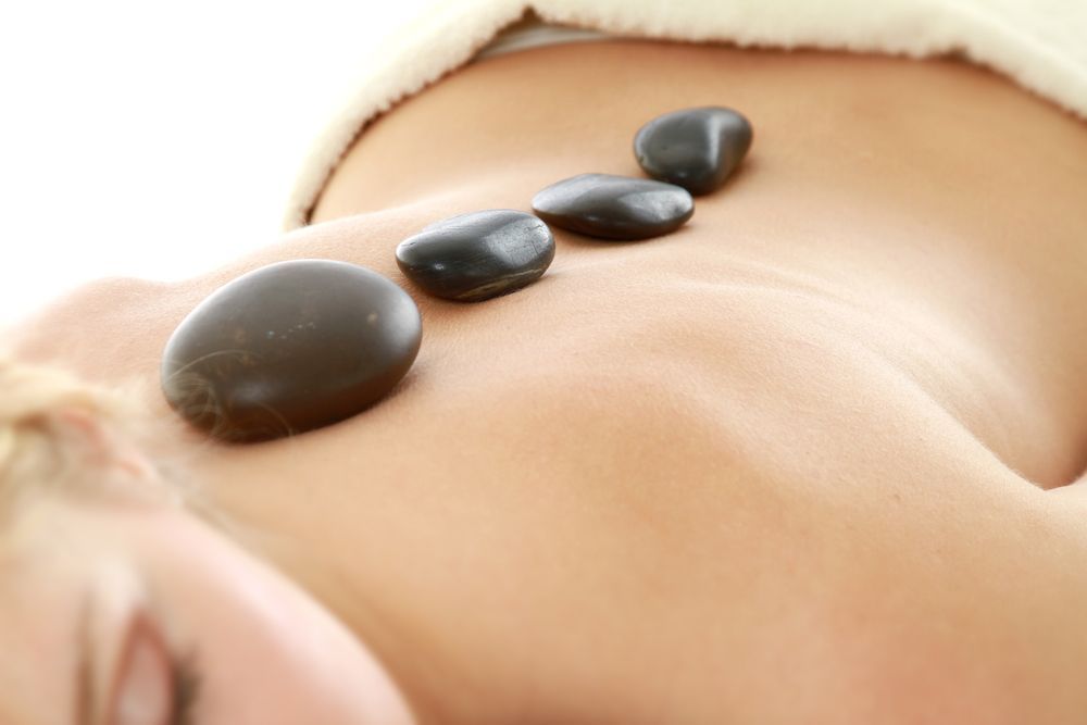 Woman Receiving a Hot Stone Massage on Her Back — Leela Thai Massage & Spa in Newtown, QLD