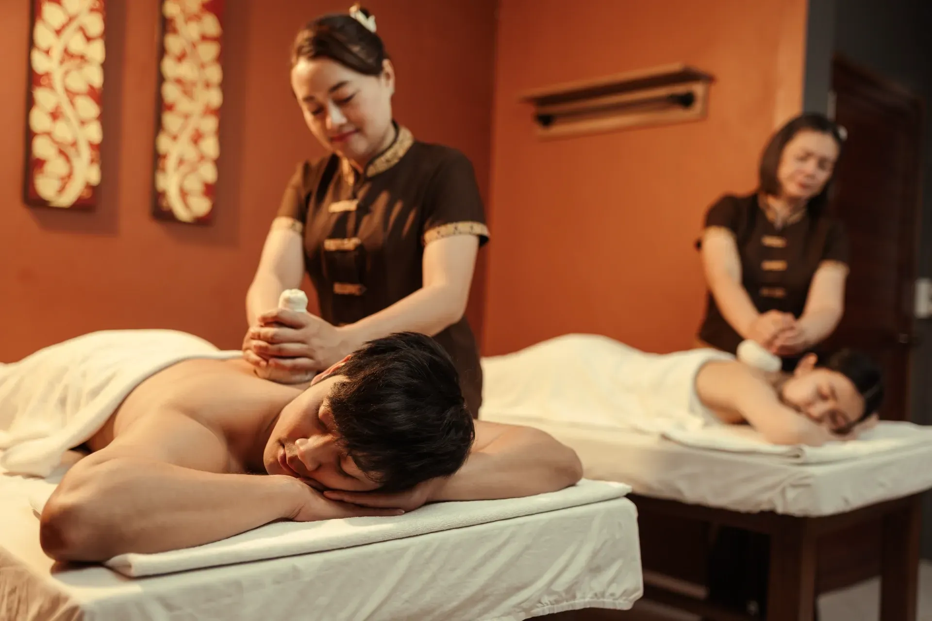 Hands Holding a Rolled, Steaming Towel Over a Person's Back — Leela Thai Massage & Spa in Newtown, QLD