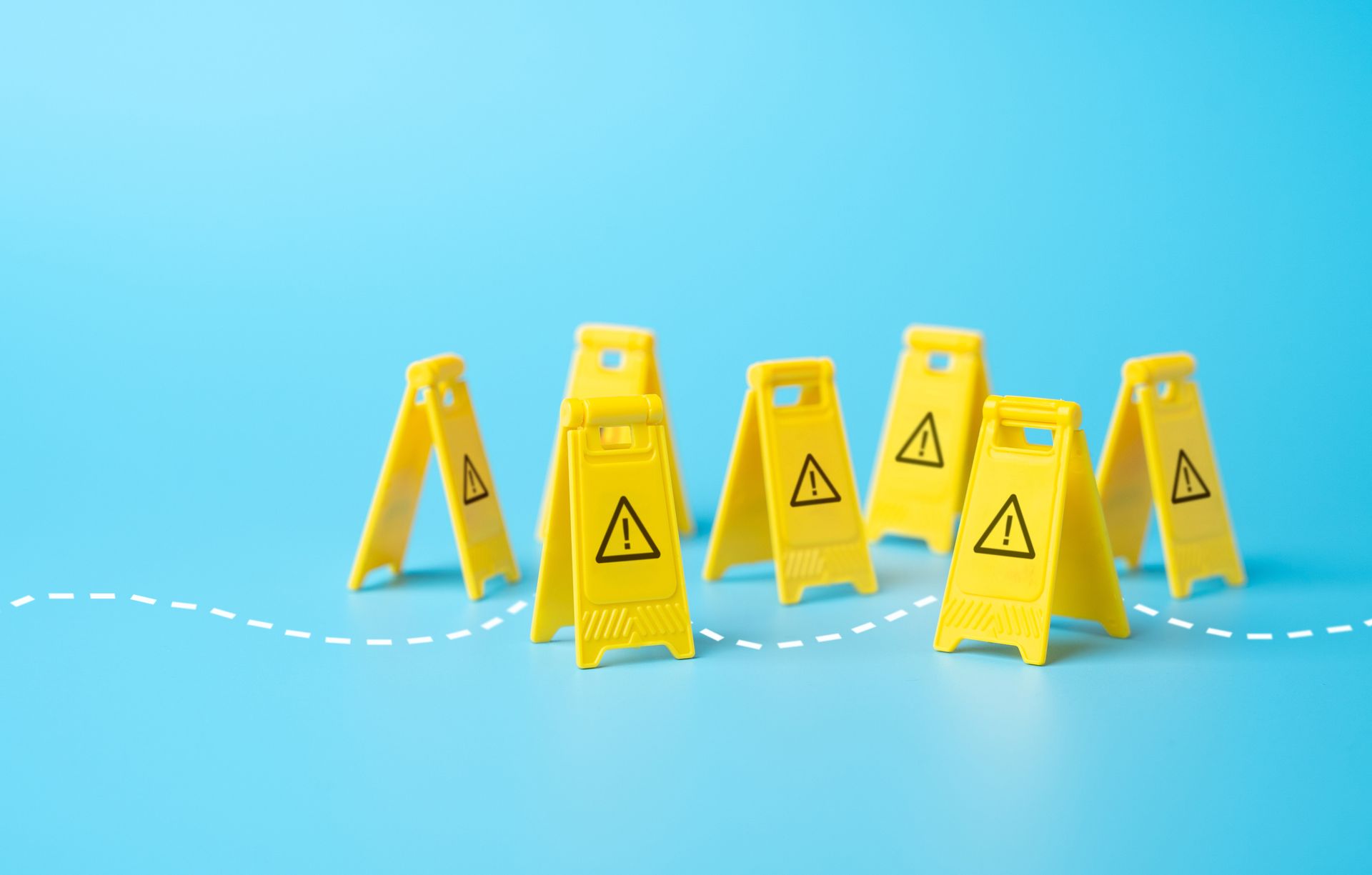 Yellow caution signs with exclamation mark symbols on a blue background.