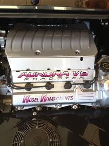 Close-up of a car engine with an Aurora V8 cover and Kugel Komponents branding.