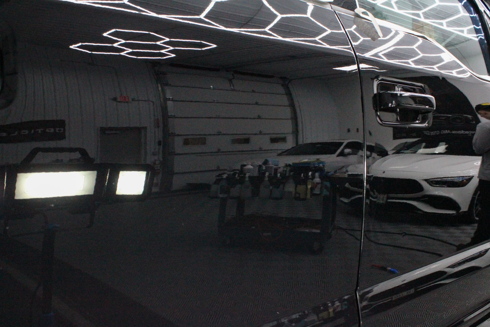 A man is polishing a car with a machine.