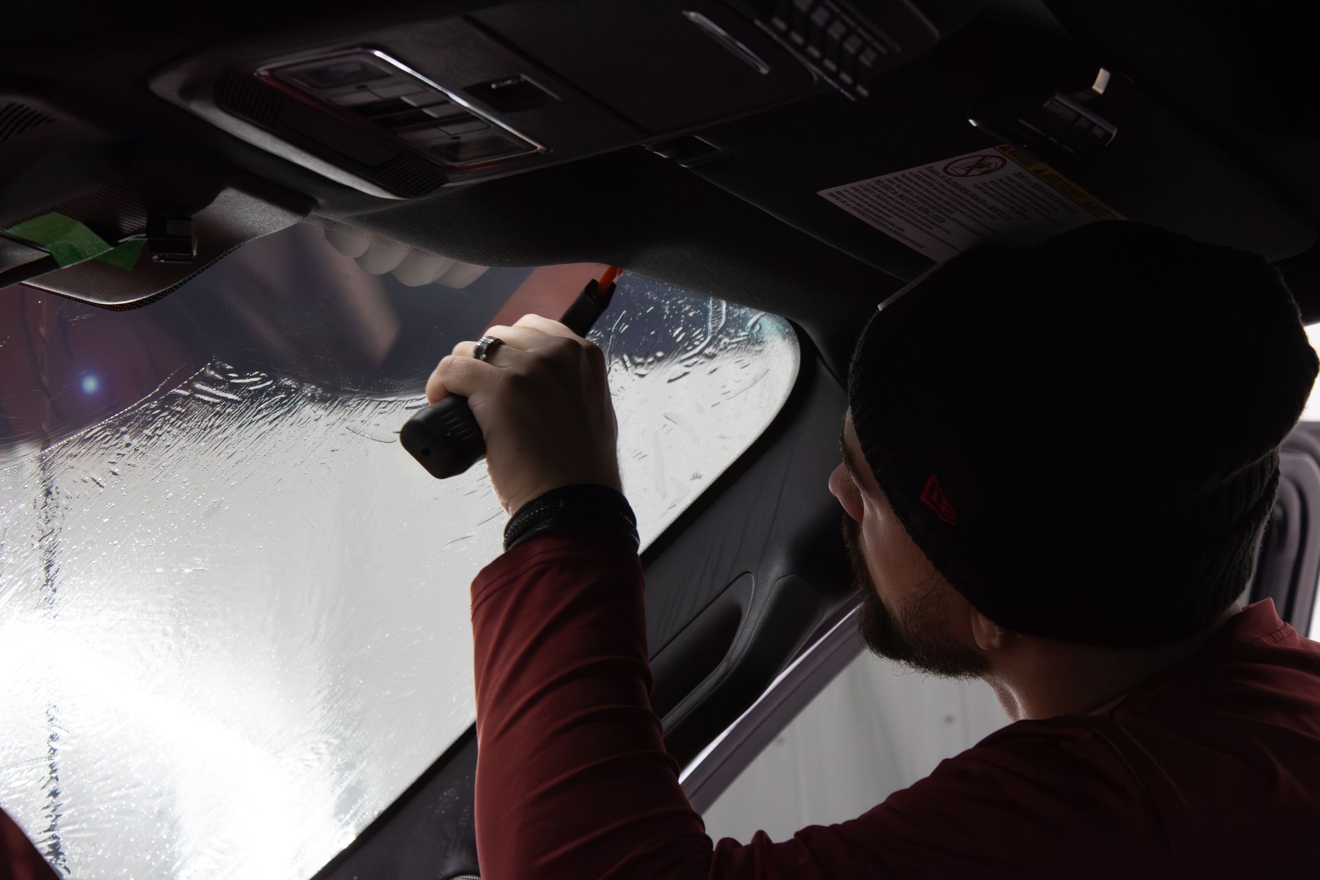 A car with the door open and a reflection of a person in the window